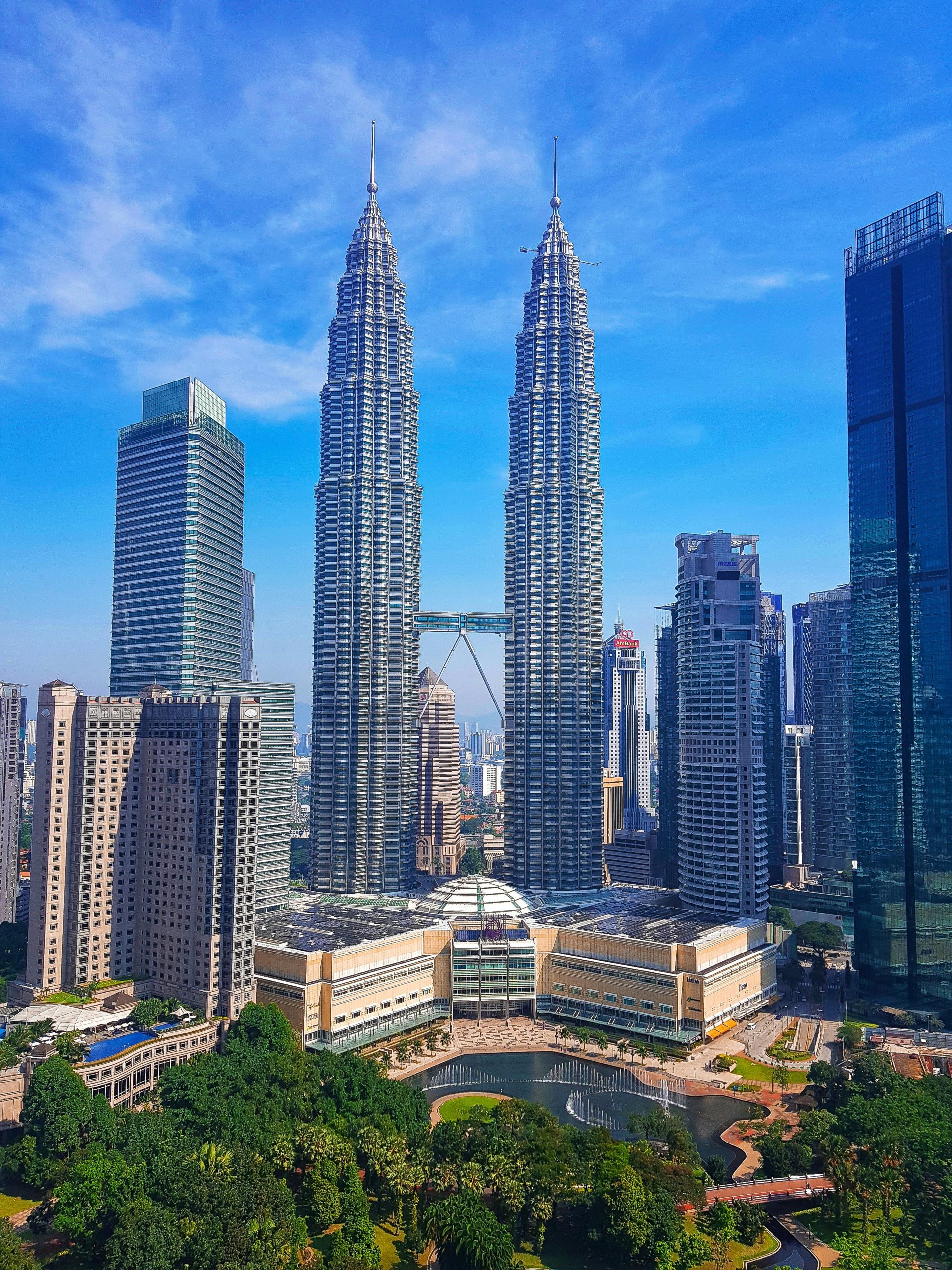Kuala Lumpur cityscape with iconic Petronas Twin Towers under a clear blue sky.